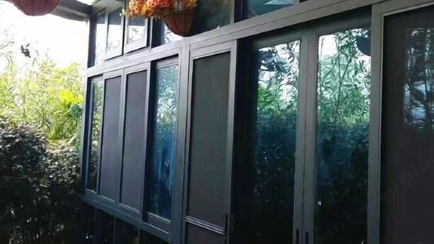 Un bâtiment moderne doté de grandes fenêtres en verre et d’une rambarde en métal.