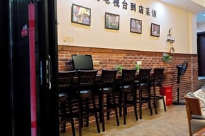 Un restaurante con paredes de ladrillo, varias mesas y sillas.