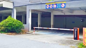 Entrada de estacionamento com portão de barreira, placa de proibido estacionar e faixa de pedestres.