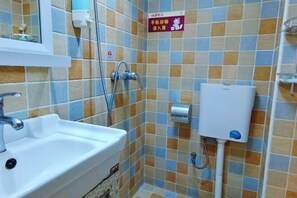 A bathroom with a sink, a shower, and a toilet. There is a sign on the wall and a soap dispenser on the wall. - Deep Breathe Inn (Zixing)