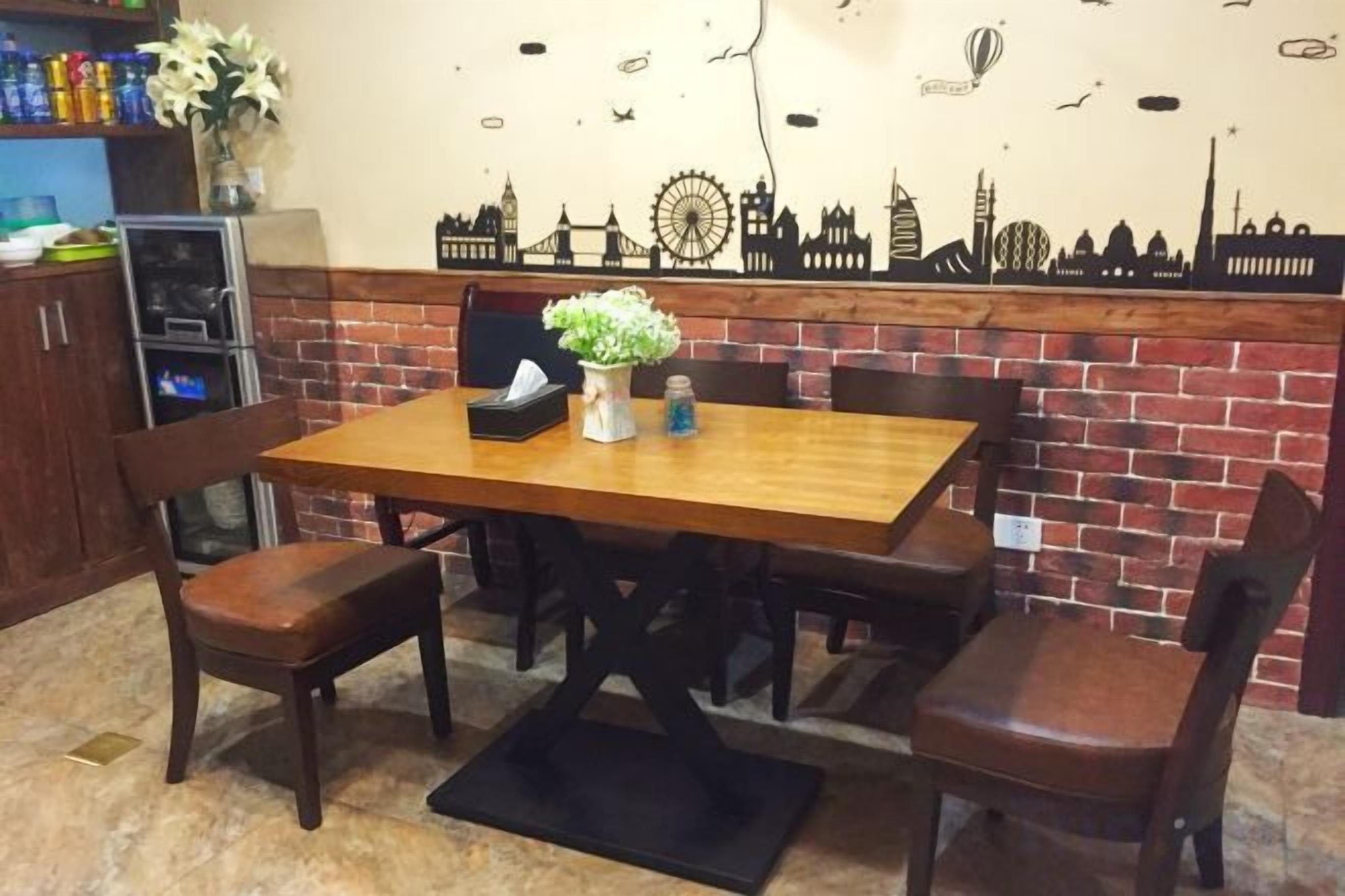 A dining area with a brick wall, a wooden table, and chairs.