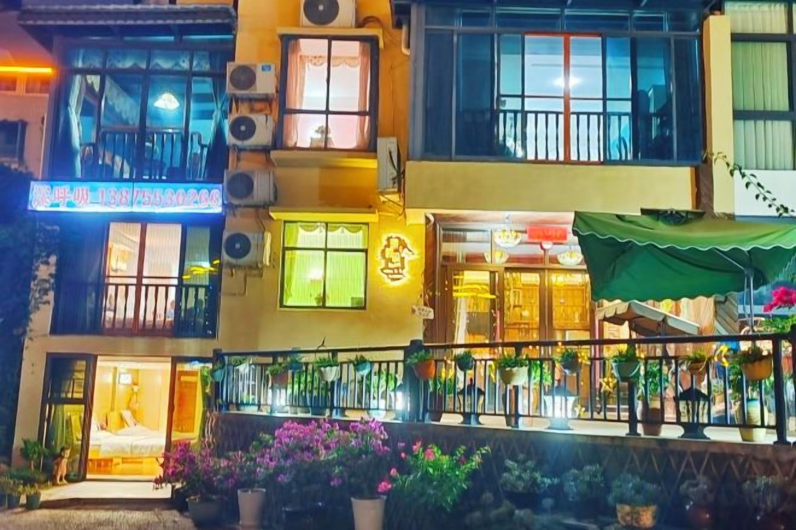 Um edifício com vários andares, varanda, aparelhos de ar condicionado e uma placa escrita em caracteres chineses.