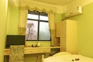 A bedroom with a bed, a window with curtains, a desk with a chair, and a wardrobe. - Deep Breathe Inn (Zixing)