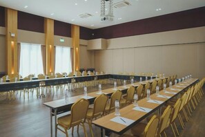 A conference room with a long table, chairs, and a projector screen. - The Cotton Tree Hometel (Khon Kaen)