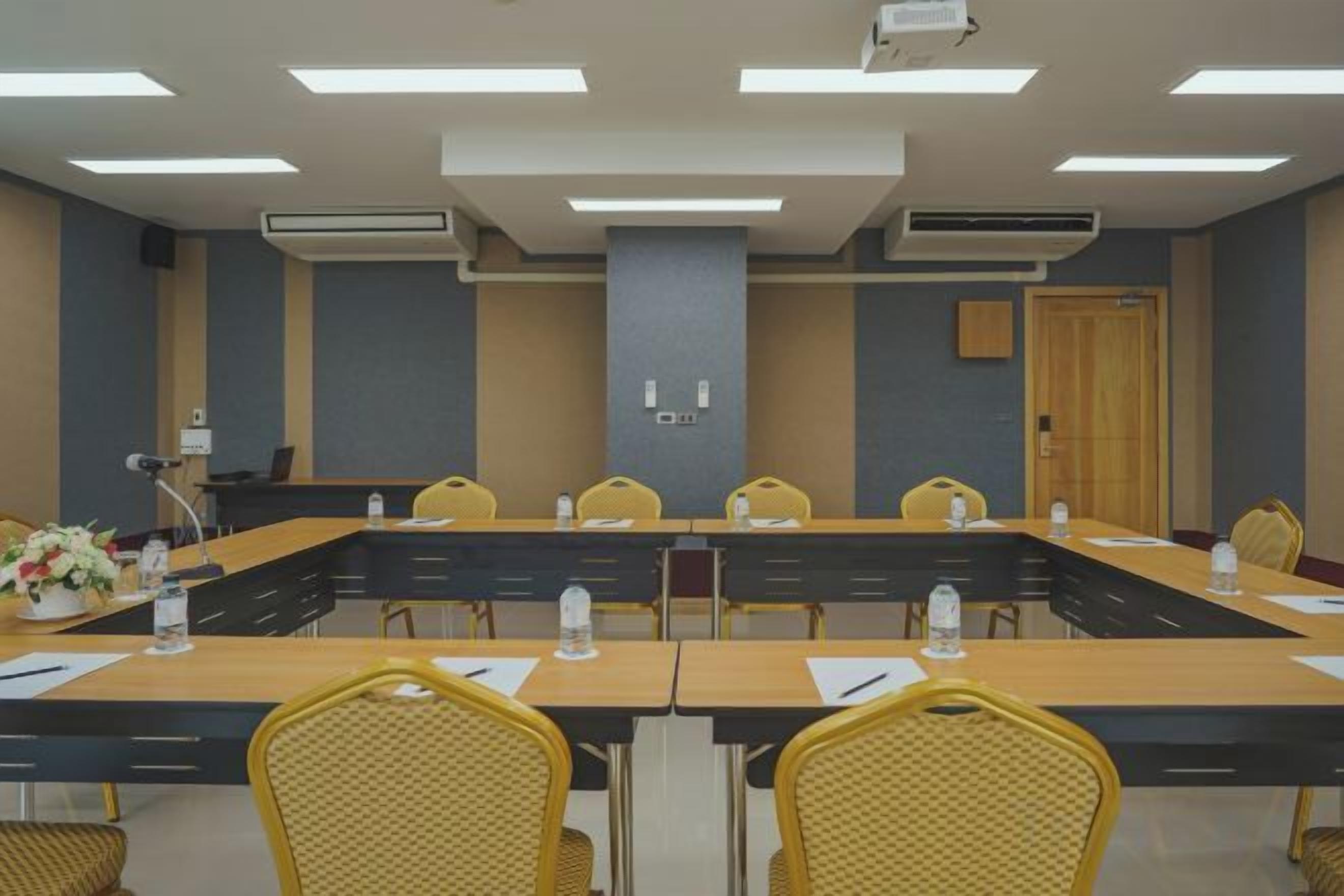 A conference room with a long table, chairs, and a podium.