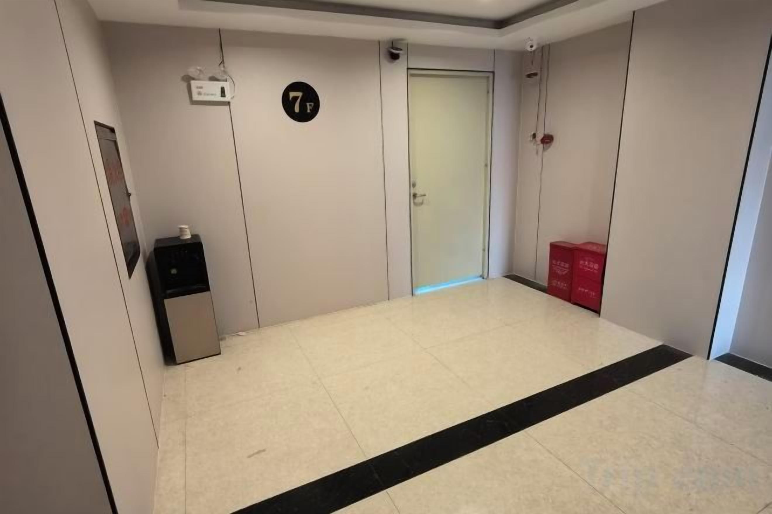 A hallway with a door marked '7F', a trash bin, and a red box on the floor.