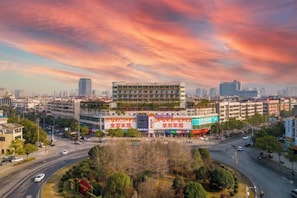 A multi-story building with a central courtyard, surrounded by roads and other buildings. - Xiyate Hotel (Xiangxiang)