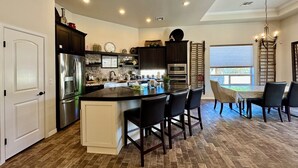 A modern kitchen with dark cabinetry, stainless steel appliances, and a central island. - Sweet Sienna Retreat (Las Cruces)