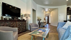 A spacious living room with a large flat-screen TV, a coffee table, and comfortable seating. - Sweet Sienna Retreat (Las Cruces)