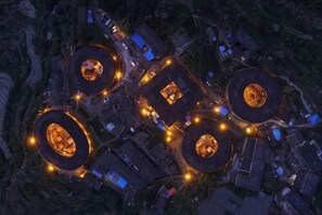 Vista aérea de un complejo con varias estructuras circulares, senderos interconectados y edificios circundantes.