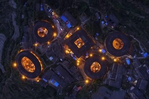 An aerial view of a complex with multiple circular structures, interconnected pathways, and surrounding buildings.