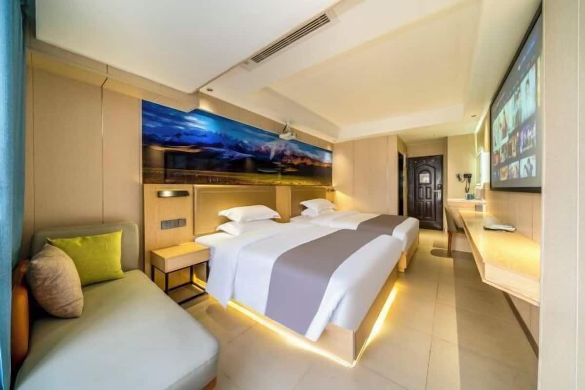 Habitación de hotel con una cama grande, un escritorio, una silla y un cuadro en la pared.