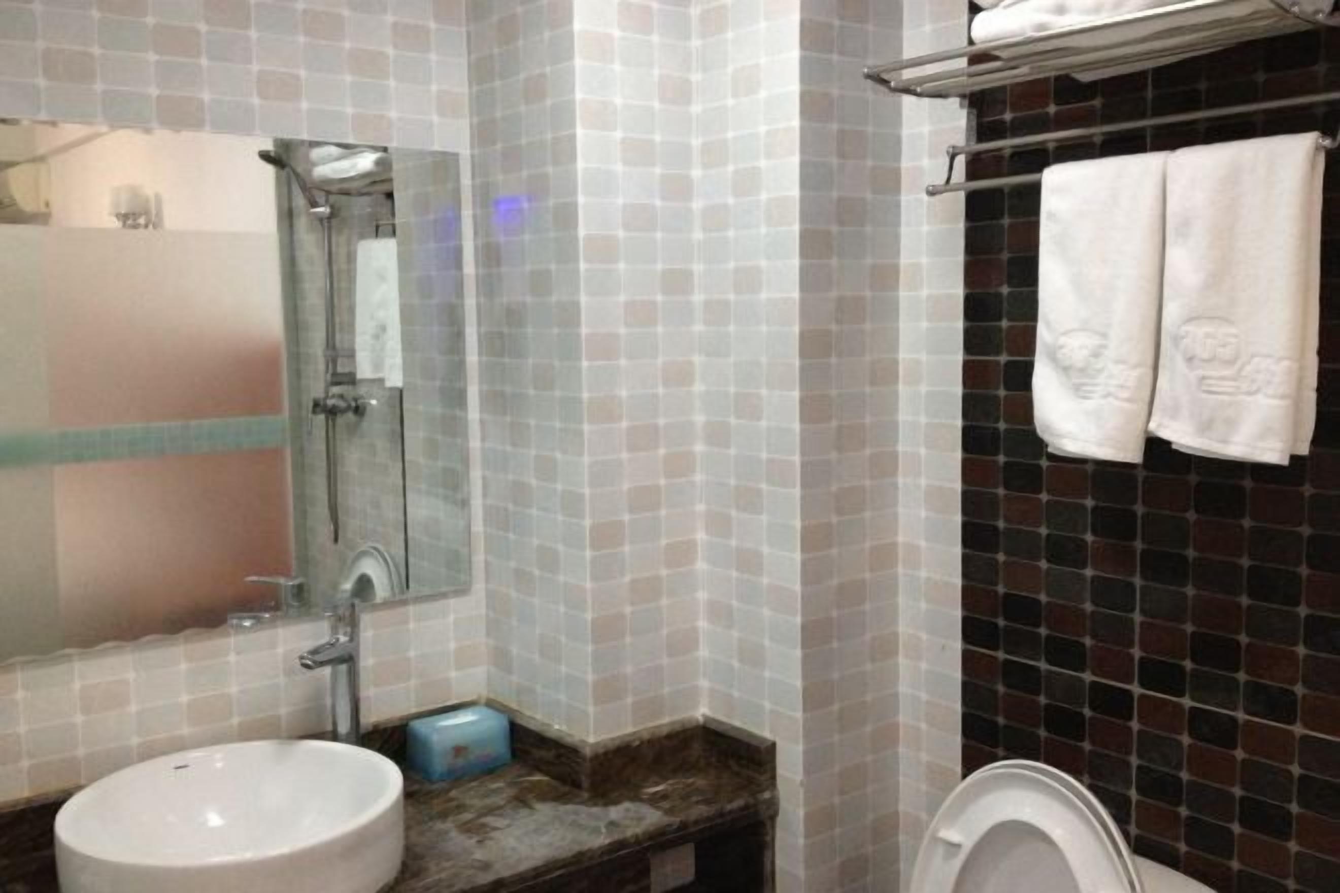 Un baño con lavamanos, espejo, ducha e inodoro.