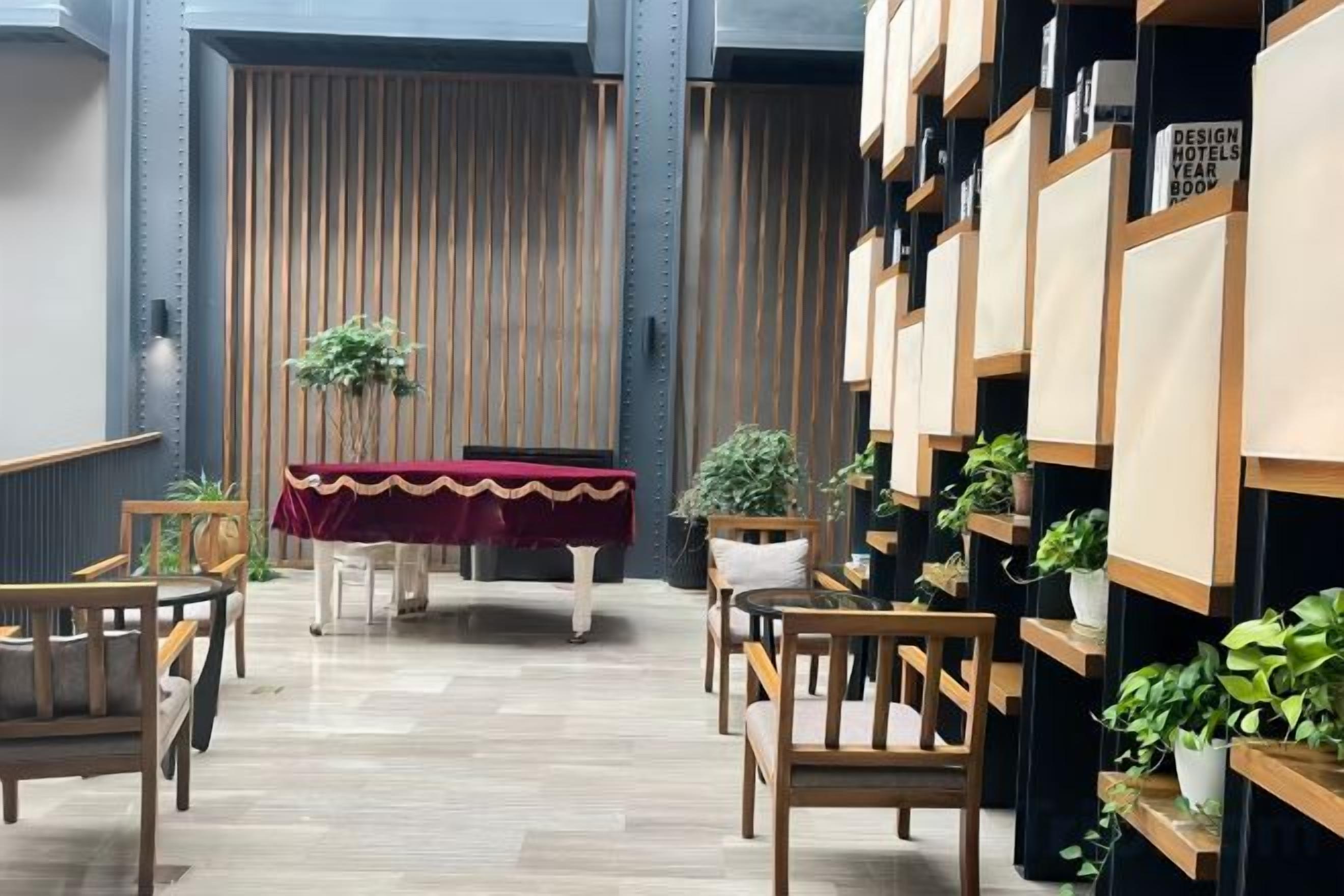 A hotel lobby with a reception desk, seating area, and a wall with framed pictures.