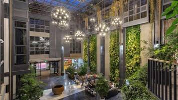 A spacious atrium with a high ceiling, large windows, and hanging spherical light fixtures.