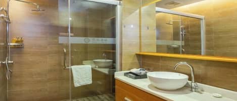 A modern bathroom with a glass-enclosed shower, a large mirror, and a wooden vanity with a white sink.