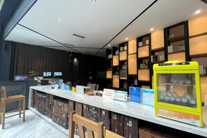 Uma área de bar moderna com bancada de mármore, assentos e uma vitrine.