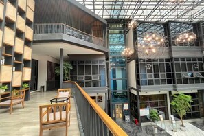 A modern interior with a mezzanine level, seating areas, and a glass ceiling. - Zunyi Wanshou Garden Hotel (Zunyi)
