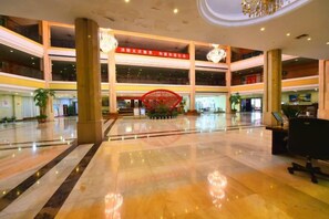 A spacious lobby with a central red decorative structure, multiple levels, and a modern chandelier. - SMQJSZ (Sanmen)
