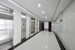 A hallway with elevators and a door at the end. - Jiacheng Boutique Apartment Hotel (Changsha)