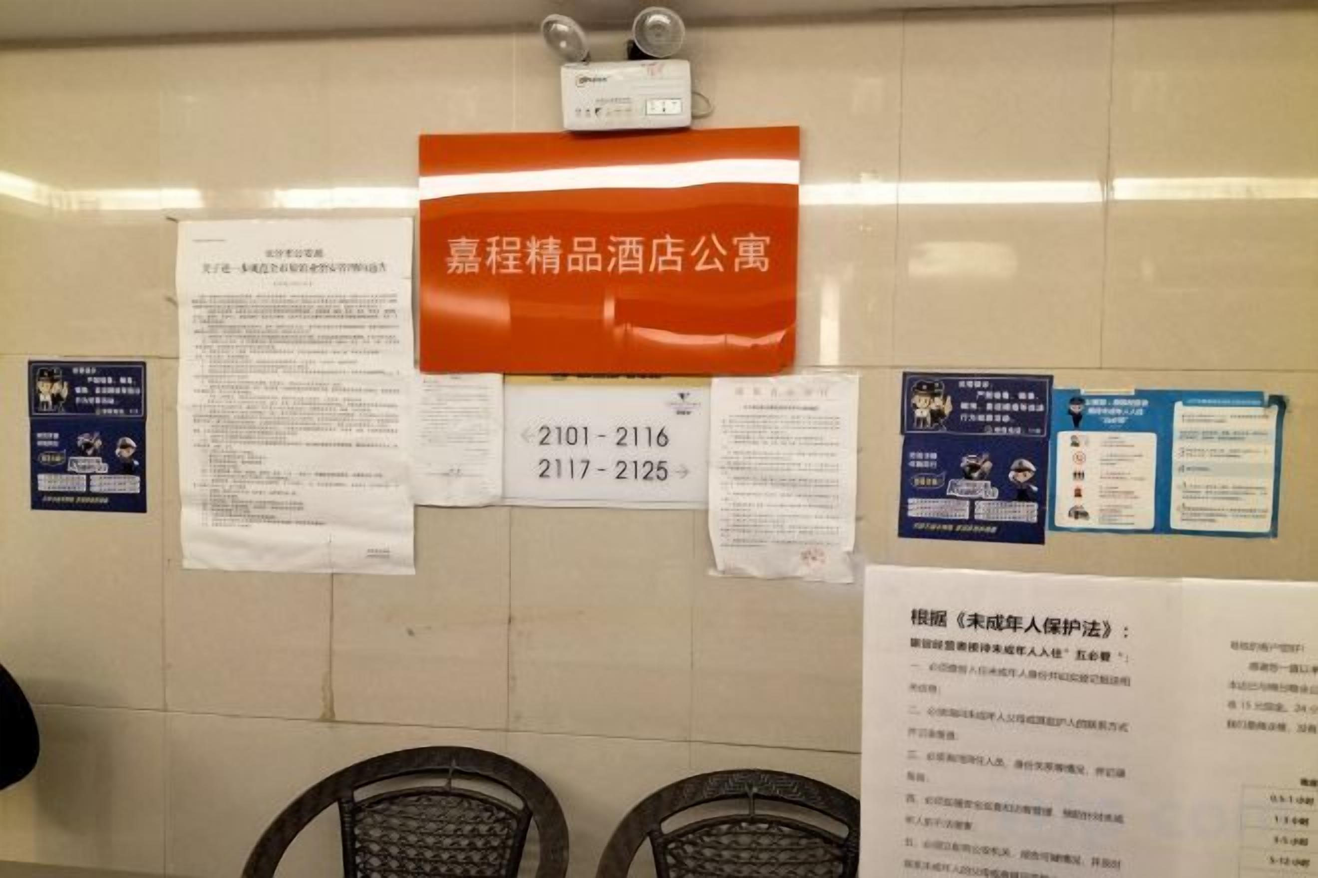 Un mur recouvert de nombreux panneaux et affiches, dont un grand panneau orange sur lequel figure un texte blanc.