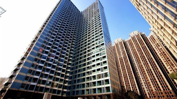 A high-rise building with a grid of windows and a clear sky. - Jiacheng Boutique Apartment Hotel (Changsha)