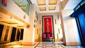 A hotel lobby with a modern design, featuring a large red sign, a glass wall, and a geometric floor pattern. - Jiacheng Boutique Apartment Hotel (Changsha)