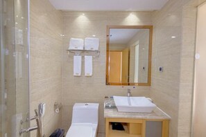 Een moderne badkamer met een douchecabine van glas, een witte wastafel en een toilet.