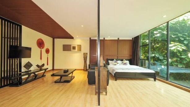 Un dormitorio moderno con una cama grande, un escritorio y una televisión.
