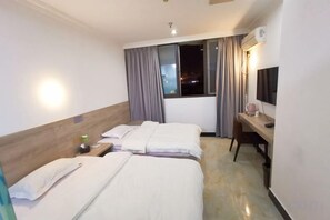 A hotel room with two beds, a desk, a chair, a TV, and a window with curtains. - Yujiacheng Hotel (Fuqing)