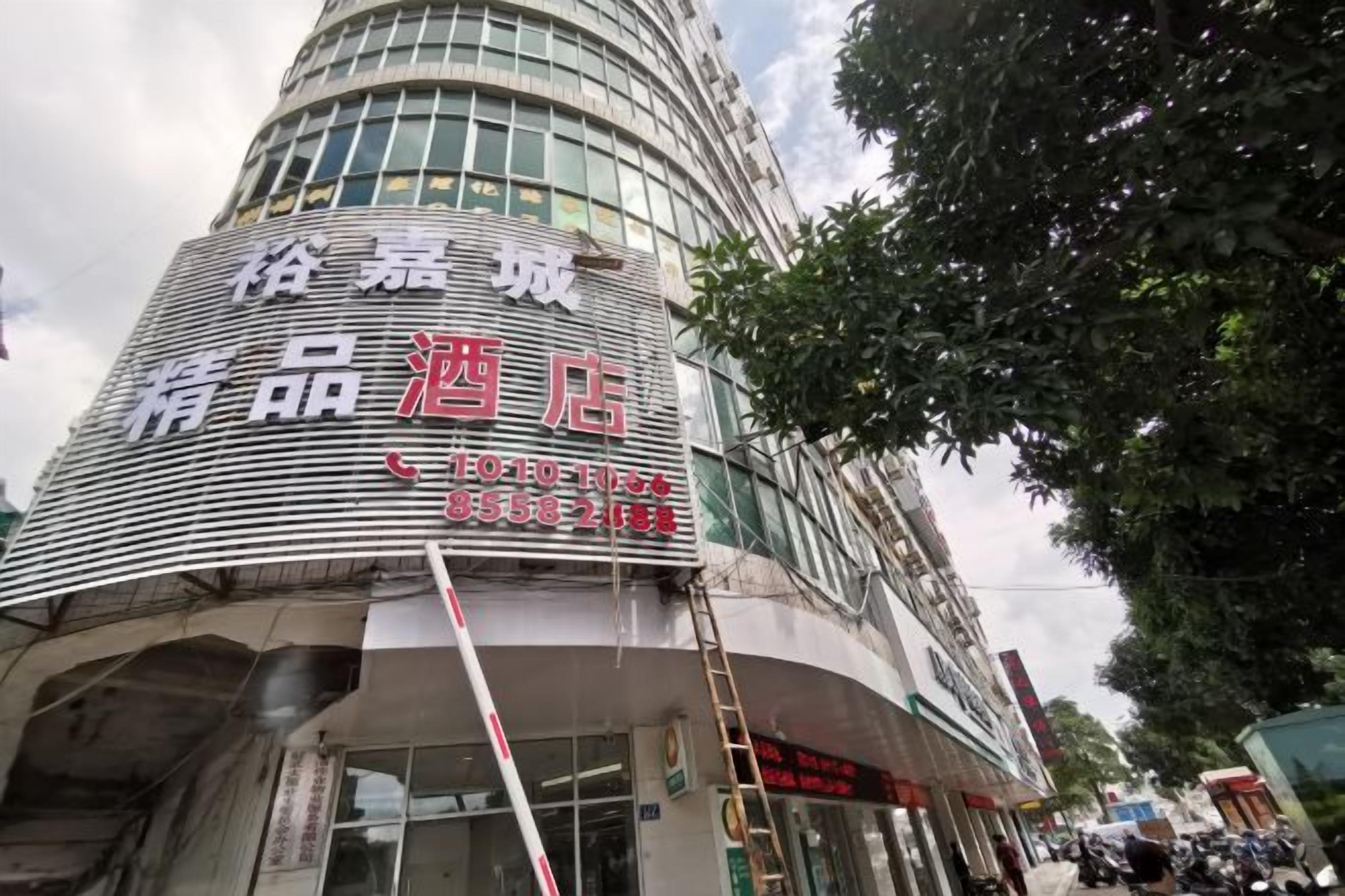 A hotel with a curved facade, large windows, and a signboard with text.