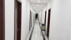 Un pasillo largo y estrecho con paredes blancas y un piso brillante y reflectante.