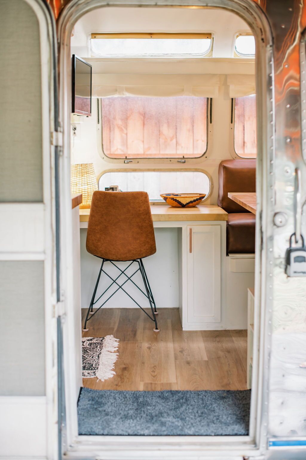 Interior compacto de autocaravana con kitchenette, comedor y zona de estar.