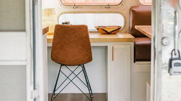 Interior compacto de autocaravana con kitchenette, comedor y zona de estar.