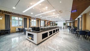 Un moderno vestíbulo de hotel con una isla central, zonas de estar y grandes ventanales.