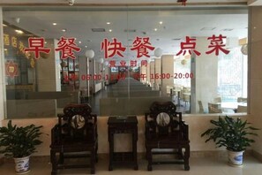A restaurant with a glass window displaying Chinese characters and operating hours. - Tiandu Hotel (Cixi)