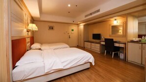 A hotel room with two beds, a desk, a chair, a television, and a mirror. - Tiandu Hotel (Cixi)