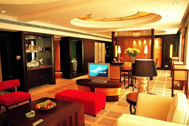 Un hall de hotel con televisor, zona de estar y bar.