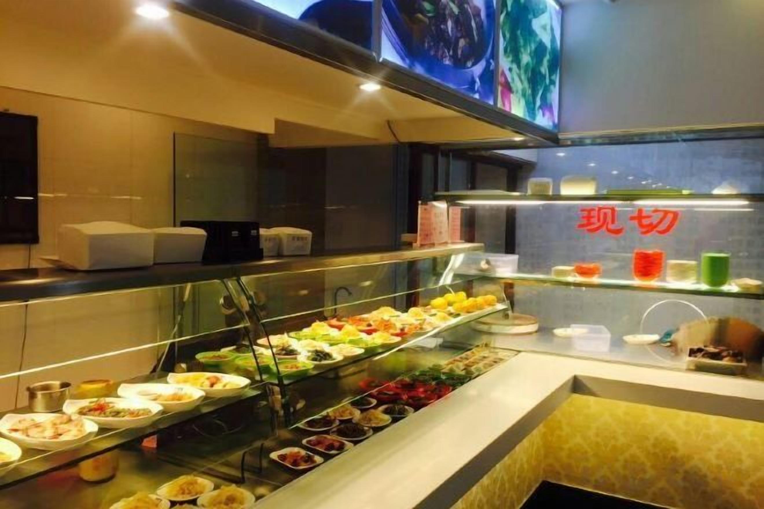 A buffet with various food items and a glass display case.