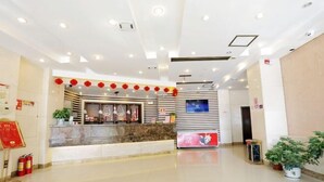 A hotel reception area with a marble counter, red lanterns, a digital screen, and potted plants. - Tiandu Hotel (Cixi)