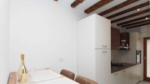 A modern kitchen with white cabinets, a wooden countertop, and a built-in oven.