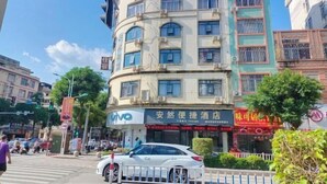 Un immeuble à plusieurs étages doté d’une façade incurvée, sur lequel on peut voir une enseigne indiquant la présence d’un hôtel et d’un restaurant.