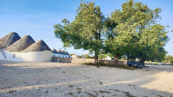 A rural setting with traditional stone houses and a gravel path. - masseria celeste (Fasano)