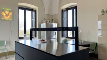 Cozinha moderna com uma ilha central, duas geladeiras e uma área de refeições com mesa e cadeiras.