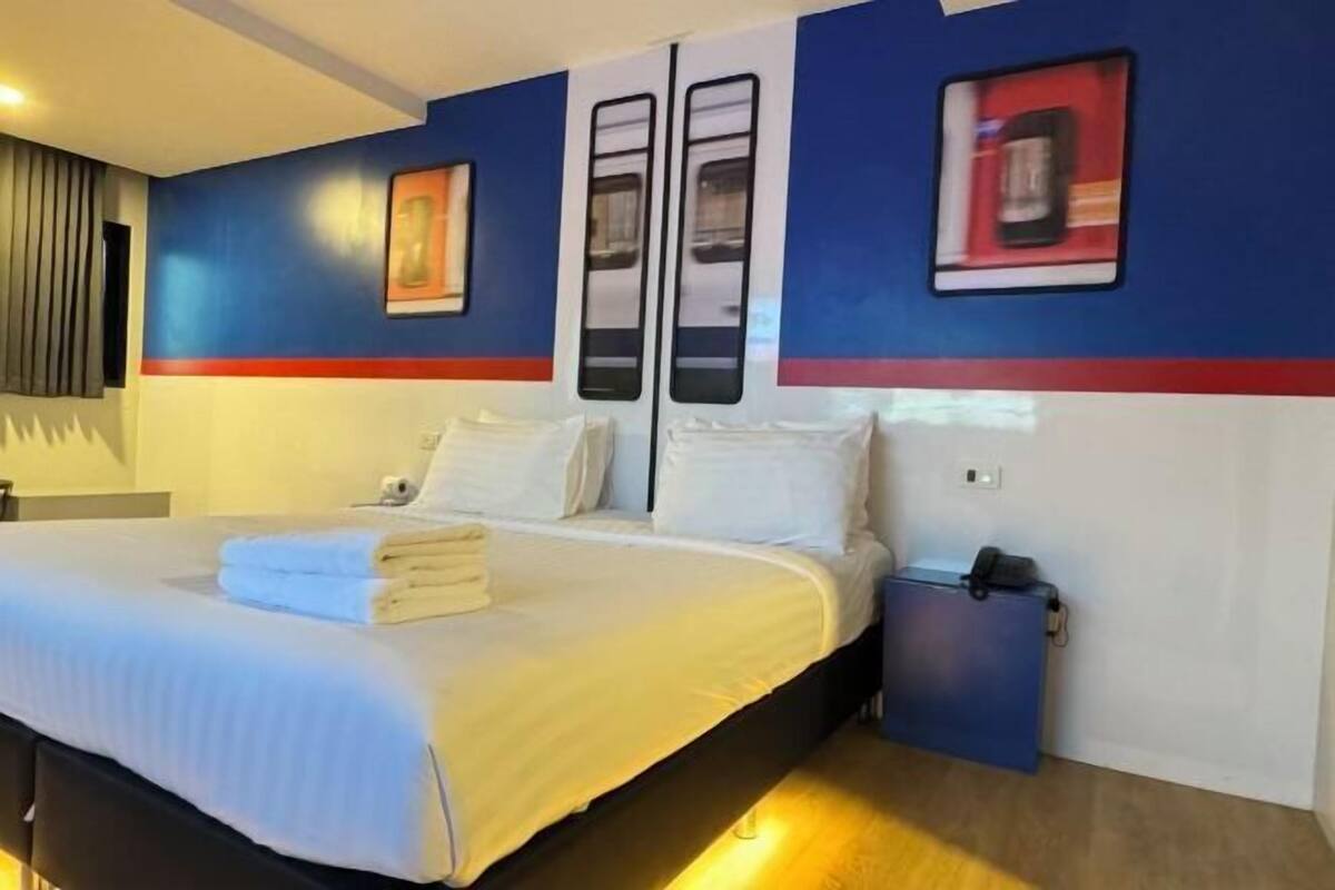 Een hotelkamer met een bed, nachtkastjes, een kledingkast en een bedtafel.
