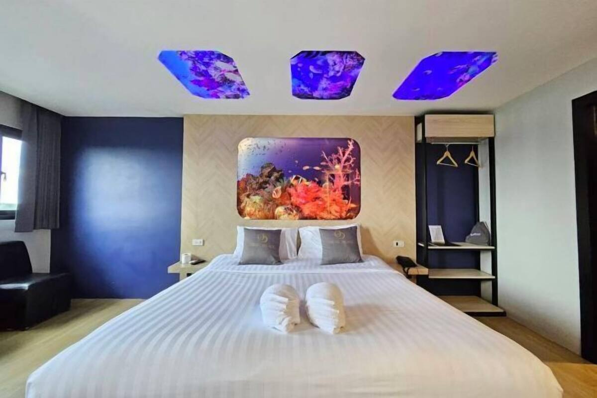 Een moderne hotelkamer met een groot bed, een nachtkastje, een bureau en een kledingkast.