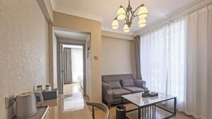 Una sala de estar moderna con una mesa de madera, un sofá gris y una máquina de café.