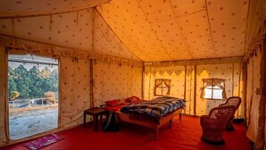 A tent with a bed, a chair, and a table. - Hill Ventures (Dharamshala)