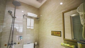 A bathroom with a shower, a hairdryer, and a caution sign on the wall.