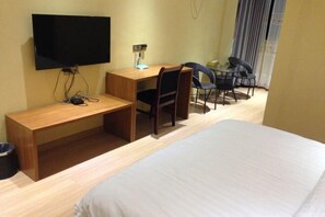 A hotel room with a bed, a desk with a chair, a television, and a small table. - Tanghe Inn, Yucheng (Rucheng)